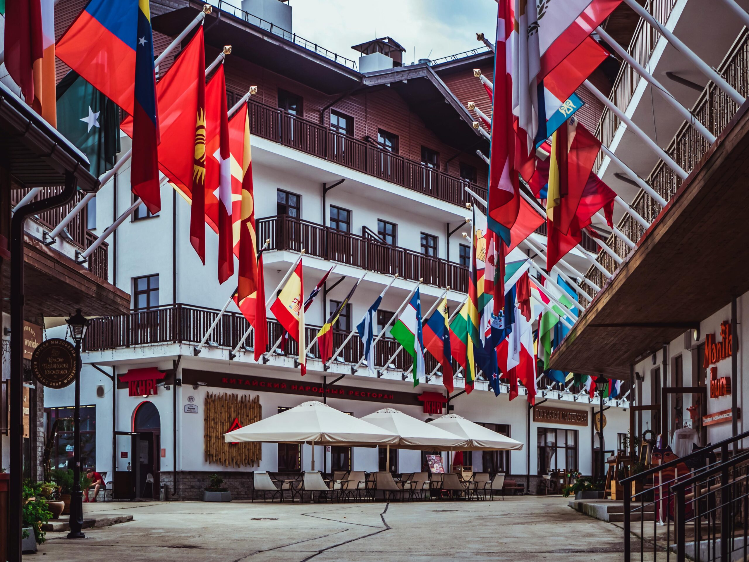 A lively urban street adorned with colorful international flags and modern architecture.